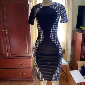 Stretchy knit hourglass dress features houndstooth drama and black panels. Wow!
